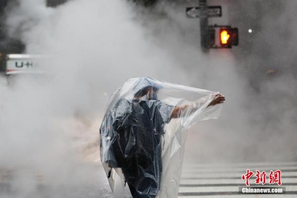 美国纽约降下暴雨 行人身披塑料布出行